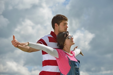 Portrait of romantic young couple in love  smiling together outdoor in nature with blue sky in backgroundの写真素材