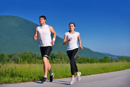 Young couple jogging in park at morning. Health and fitness.の写真素材