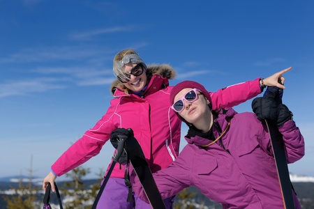 happy friends group of woman girls have fun at winter season at beautiful sunny  snow day with blue sky in backgroundの写真素材