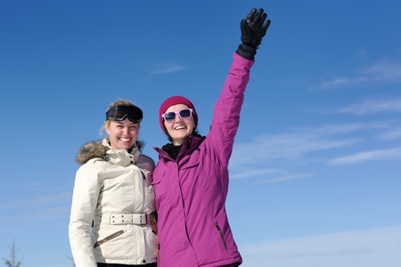happy friends group of woman girls have fun at winter season at beautiful sunny  snow day with blue...