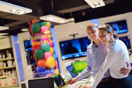 people in consumer electronics  retail store looking at latest laptop, television and photo camera...