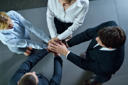 business people group joining hands and representing concept of friendship and teamwork,  low angle viewの写真素材