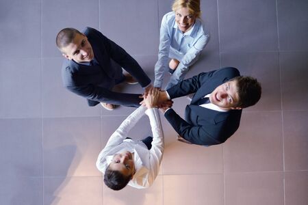 business people group joining hands and representing concept of friendship and teamwork,  low angle viewの写真素材