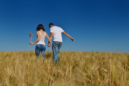 happy young couple in love have romance and fun at wheat field in summerの写真素材