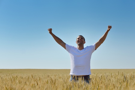 young man in wheat field representing success agriculture and freedom conceptの写真素材