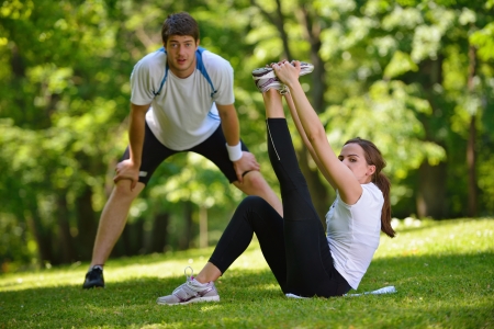 young health couple doing stretching exercise relaxing and warm up after jogging and running in park