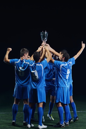 soccer players team group celebrating the victory and become champion of game while holding win coupの写真素材