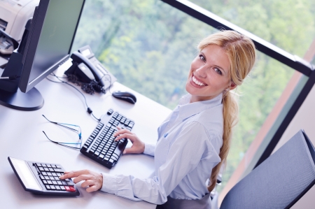 Portrait of a beautiful business woman working on her desk in an office environment.の写真素材
