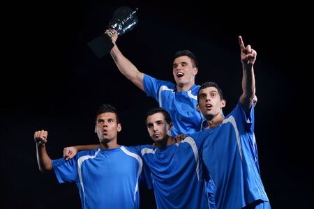 soccer players team group celebrating the victory and become champion of game while holding win coupの写真素材