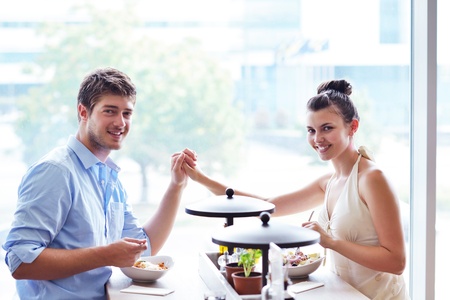 A young couple sitting at a table and have lunch at an outdoor restaurantの写真素材