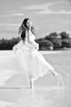 asian  bride with a veil on the beach in the sky and blue sea  honeymoon on the fantastic island at summerの写真素材
