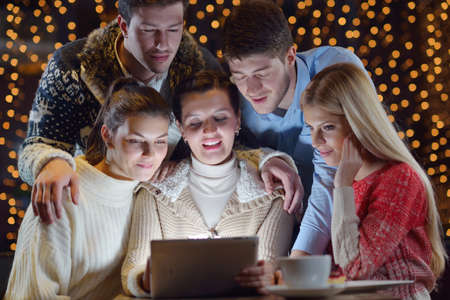 Group of happy people looking at a tablet computer
