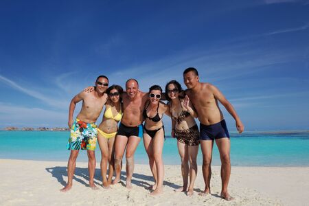group of happy young people have fun and joy at the  white sand  beach on beautiful summer  dayの写真素材