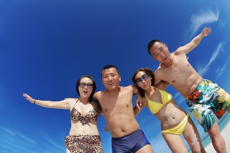 group of happy young people have fun and joy at the  white sand  beach on beautiful summer  dayの写真素材