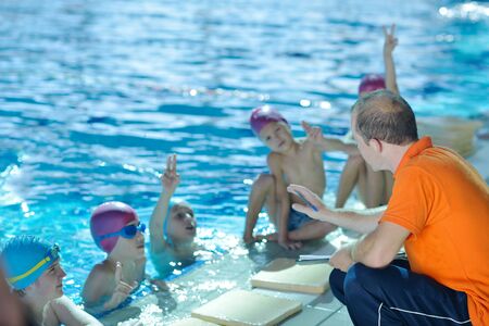 happy children kids group  at swimming pool class  learning to swimの写真素材