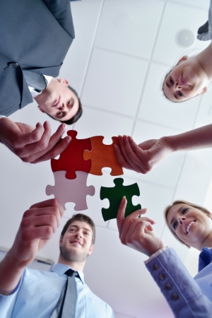 Group of business people assembling jigsaw puzzle and represent team support and help conceptの写真素材