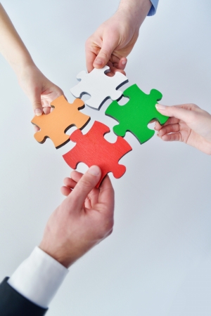 Group of business people assembling jigsaw puzzle and represent team support and help conceptの写真素材