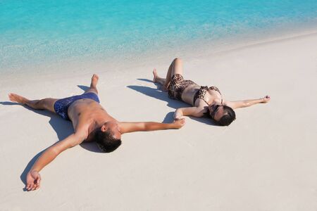 happy young asian couple enjoying summer and have on beautiful white sand beachの写真素材