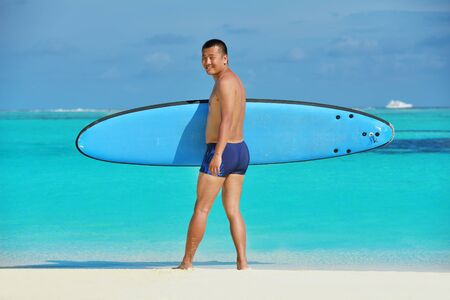 Man with surf board on beautiful tropical beach  beachの写真素材