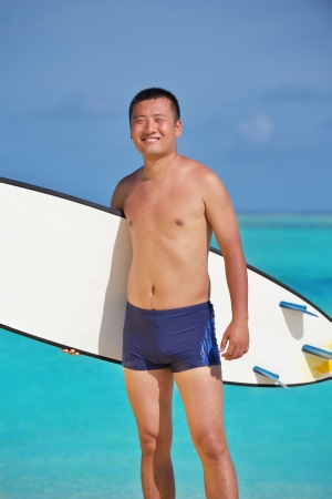 Man with surf board on beautiful tropical beach  beachの写真素材