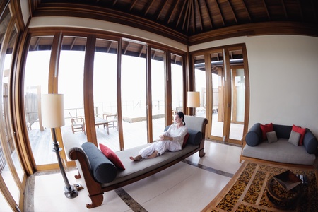 happy young woman relax at home on sofa in bright living room and watching tvの写真素材