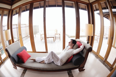 happy young woman relax at home on sofa in bright living room and watching tv