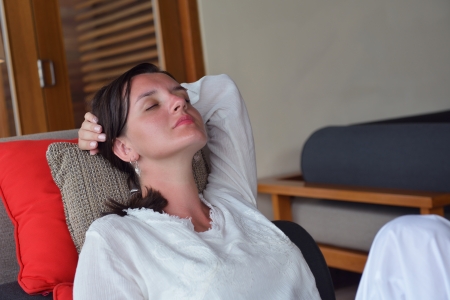 happy young woman relax at home on sofa in bright living room and watching tvの写真素材