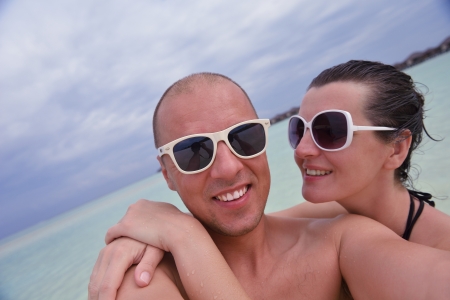 happy young couple have fun and relax at summer vacation on background maldives travel location and beautiful white sand beachの写真素材