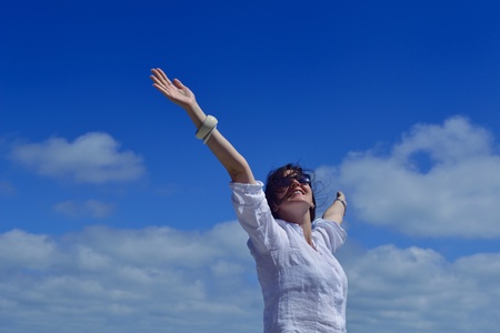 healthy Happy  young woman with spreading arms, blue sky with clouds in background  - copyspaceの写真素材