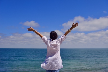 healthy Happy  young woman with spreading arms, blue sky with clouds in background  - copyspace