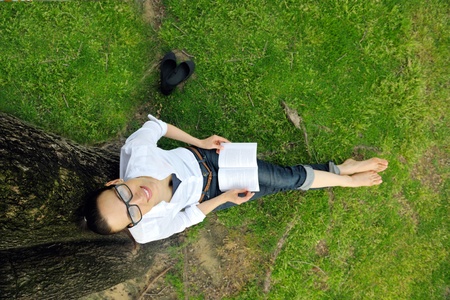 Young student woman reading a book and study in the parkの写真素材