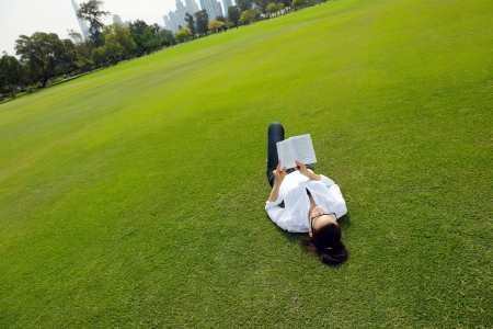 Young student woman reading a book and study in the parkの写真素材