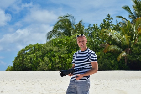 photographer taking photo of models couple on beautiful tropical beach at summerの写真素材