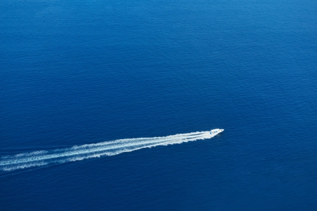 fast motor speed boat travel with splash and wake on blue tropical sea backroundの写真素材