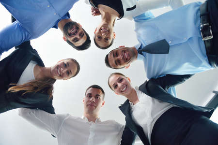 Closeup of happy business people with their heads together representing concept of ftiendship and teamwork isolated on white backgroundの写真素材