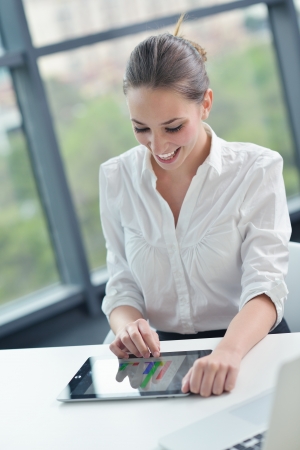 portrait of Young pretty business woman work on  notebook computer  in the bright modern office indoorsの写真素材