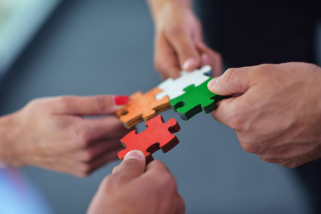 Group of business people assembling jigsaw puzzle and represent team support and help conceptの写真素材