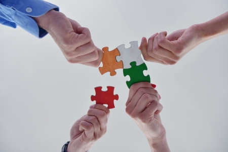 Group of business people assembling jigsaw puzzle and represent team support and help conceptの写真素材