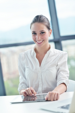 portrait of Young pretty business woman work on  notebook computer  in the bright modern office indoorsの写真素材