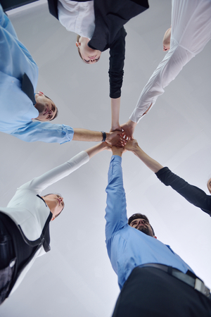 business people group joining hands and representing concept of friendship and teamwork,  low angle...