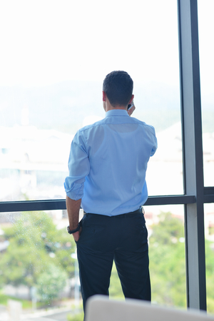 business man talking by cellphone in officeの写真素材