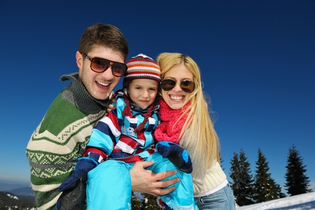 Winter season. Happy family having fun on fresh snow on vacation.の写真素材