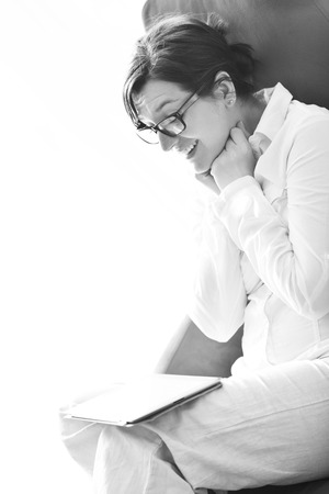 Young woman at home relaxing in her lliving room reading a digital tablet PC surf internet and workの写真素材