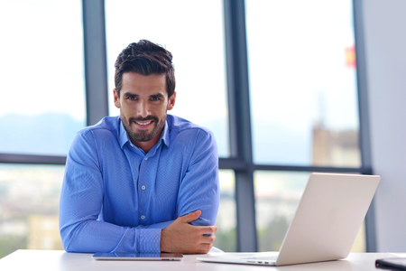 happy young business  man work in modern office on computerの写真素材
