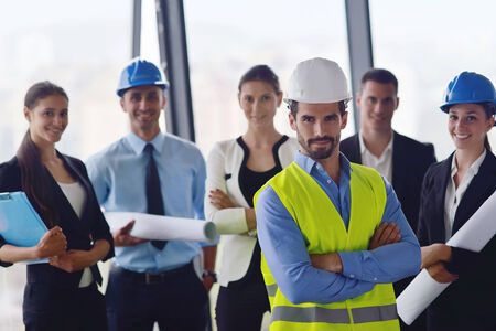 business people group on meeting and presentation  in bright modern office with construction engineer architect and worker looking building model and blueprint  plansの写真素材