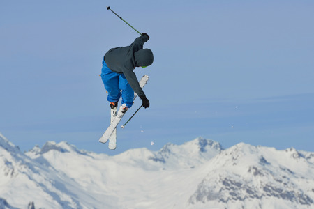 jumping skier at mountain winter snow fresh suny dayの写真素材
