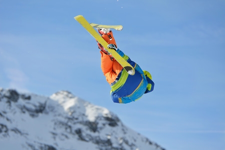 jumping skier at mountain winter snow fresh suny dayの写真素材
