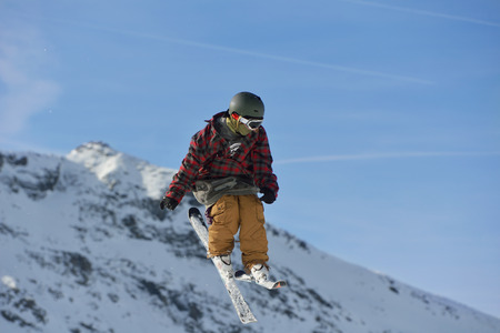 jumping skier at mountain winter snow fresh suny dayの写真素材
