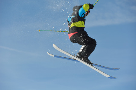 jumping skier at mountain winter snow fresh suny dayの写真素材