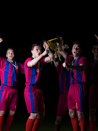 soccer players team group celebrating the victory and become champion of game while holding win coupの写真素材